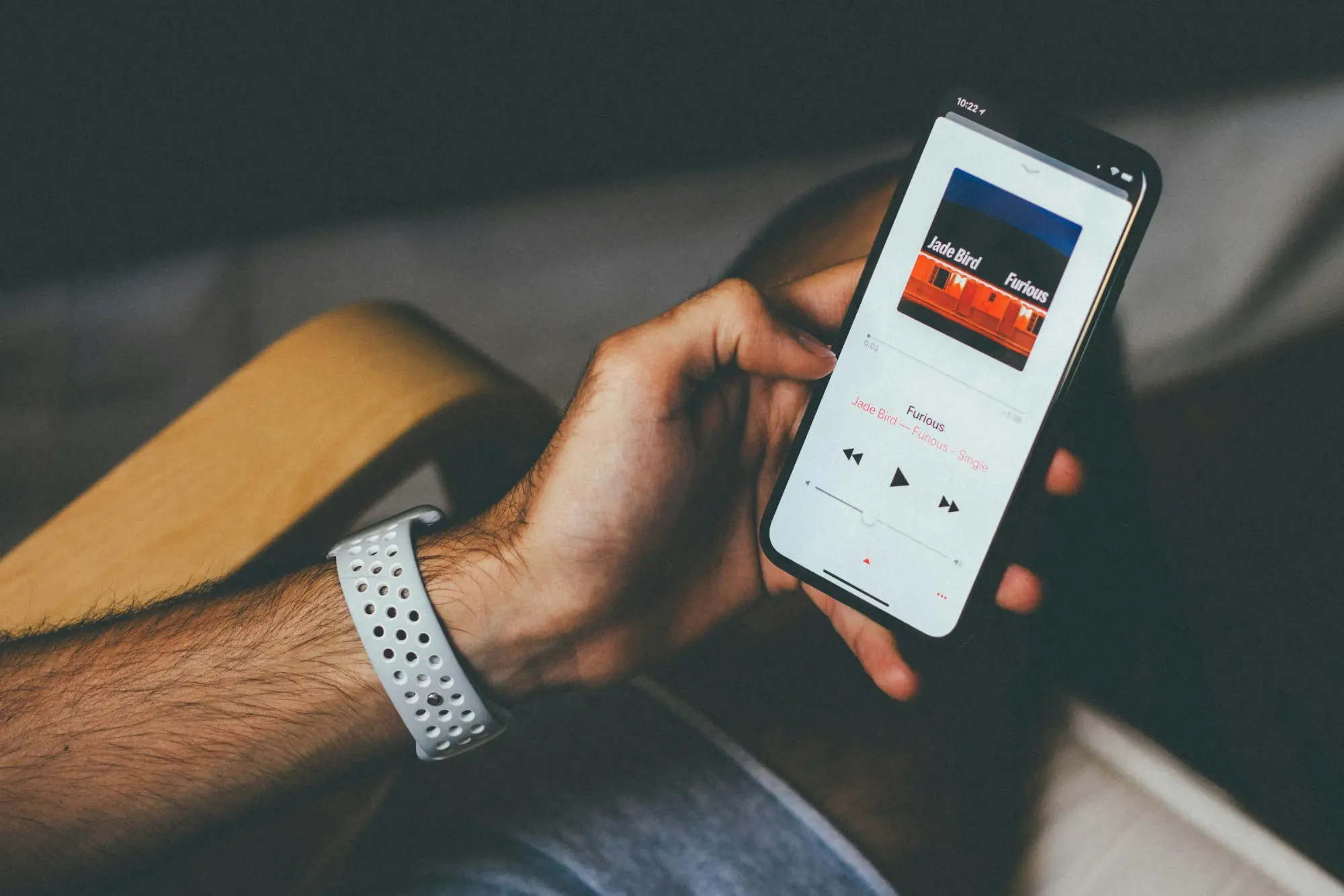 Una mano tiene uno smartphone con un lettore musicale sullo schermo
